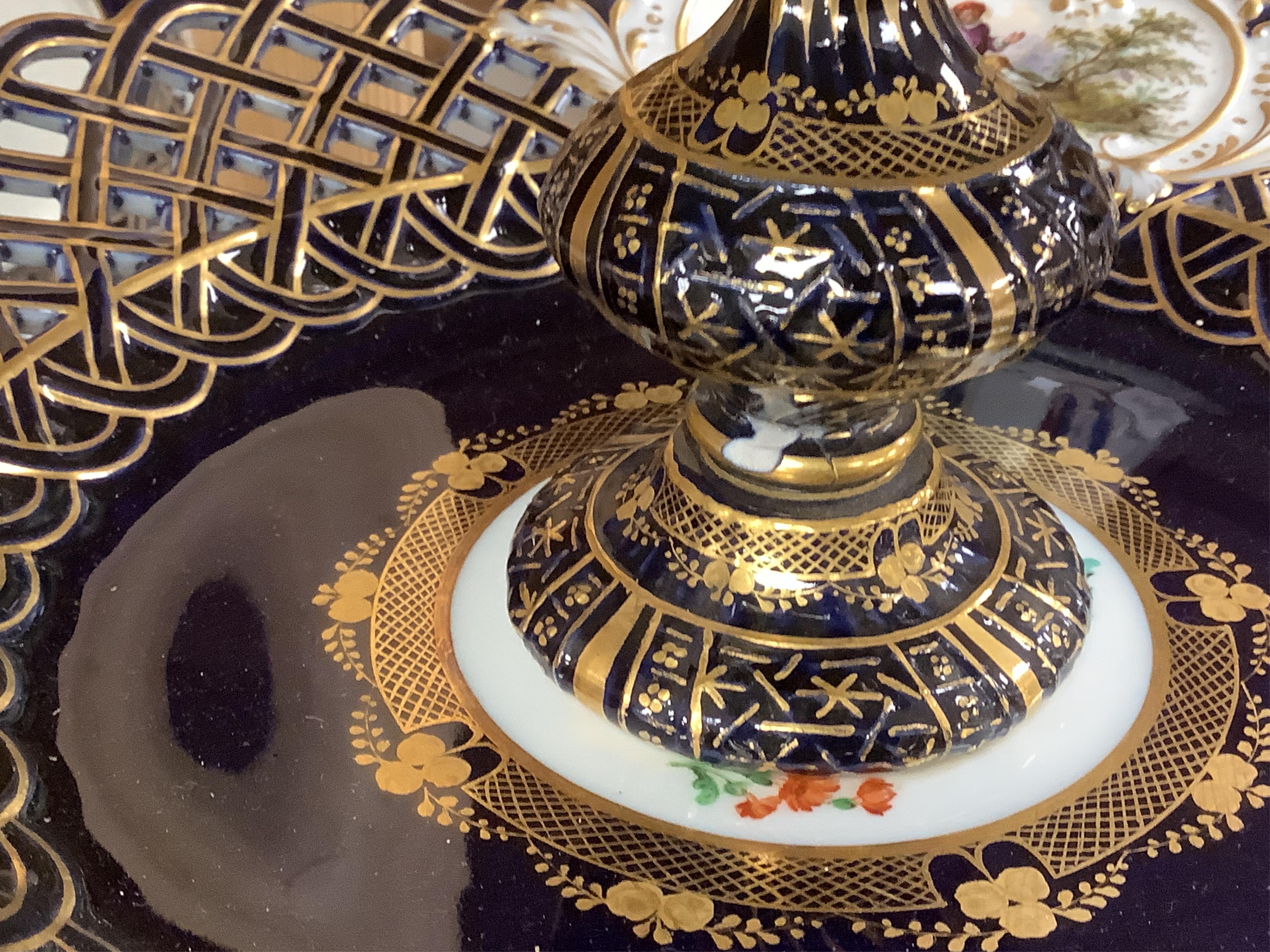 A pair of late 19th century Meissen three tier cake stands with figural tops, 48cm high